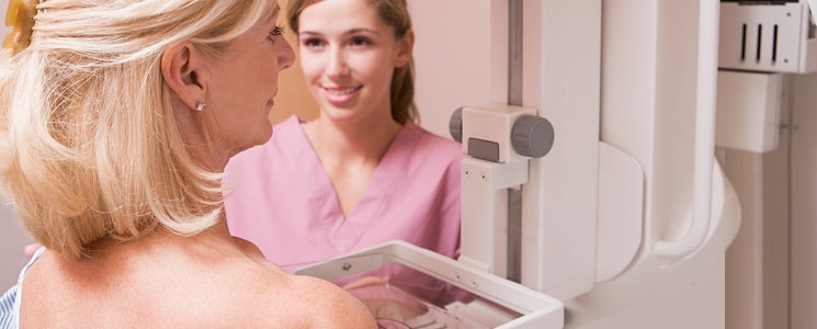 patient receiving mammogram with doctor beside her smiling