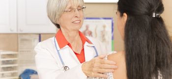 Woman receiving breast exam, mammogram at doctor's office or hospital.