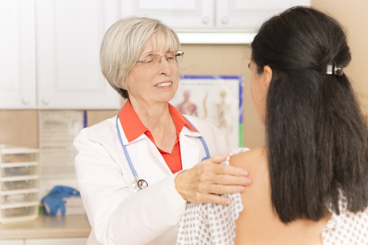 Woman receiving breast exam, mammogram at doctor's office or hospital.