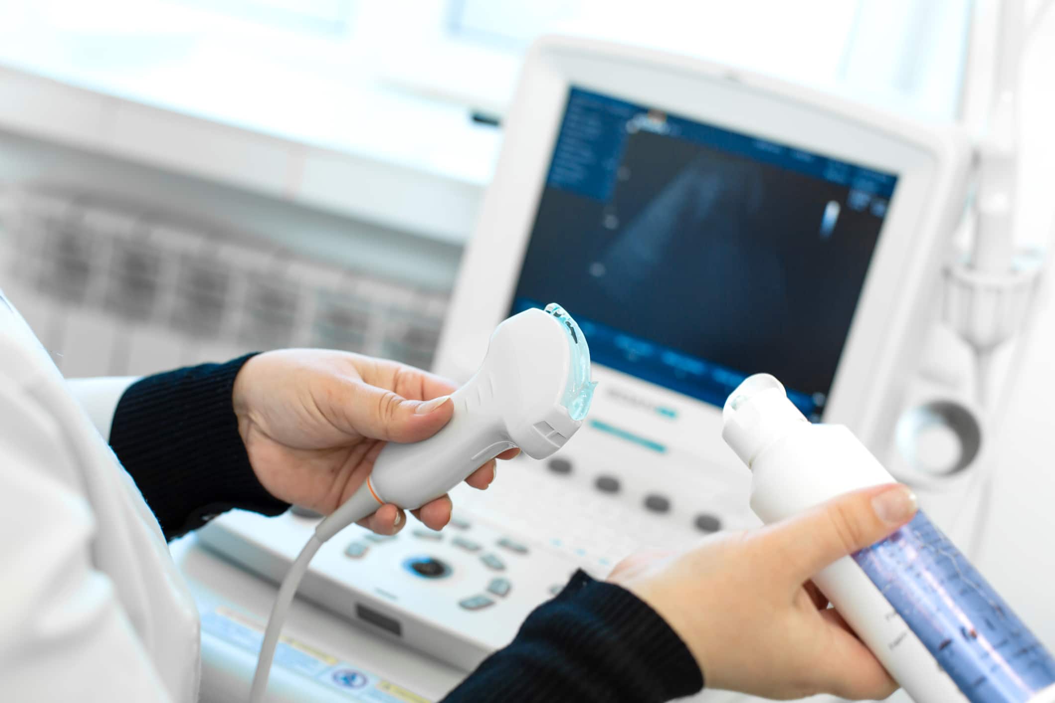 doctor's hands getting lubricant and mammogram machine ready for exam in office