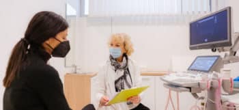 Doctor and patient with protective face masks during the medical examination