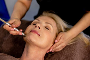 Beautiful senior woman at the spa getting a PRP vampire facial treatment on her face - beauty concepts